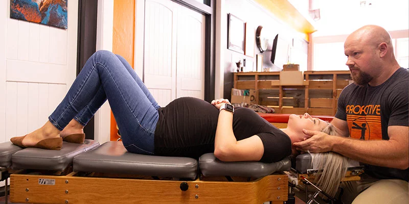 Dr. Lee Grant, prenatal family chiropractor in Ardmore, OK, giving a pregnant patient a chiropractic adjustment